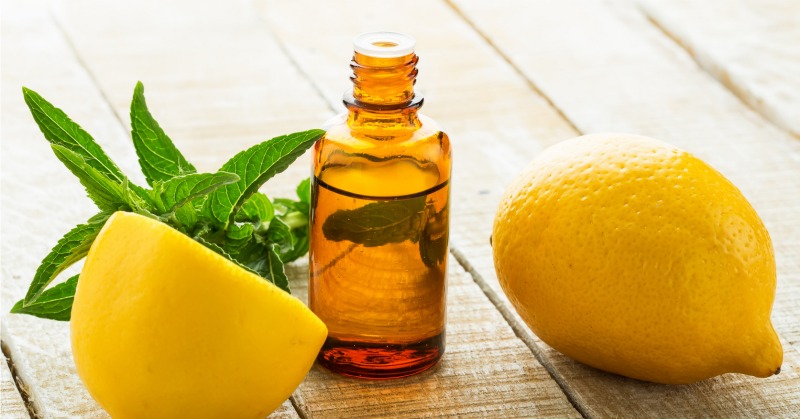 Essential aroma oil with lemon and mint on wooden background. Selective focus.